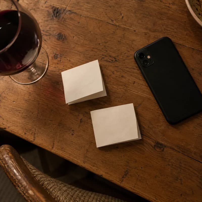 Twee handgeschreven briefjes met vragen naast een dichtgeklapte telefoon